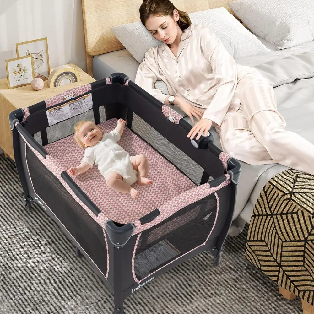 Portable Baby Playard with Bassinet, Changer, Mattress, Storage, and Toys in Pink